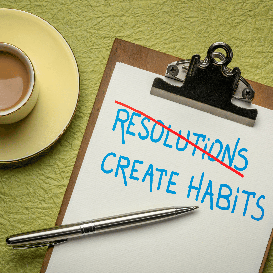 clip board with resolutions crossed out in red and create habits written underneath. coffee mug in the corning